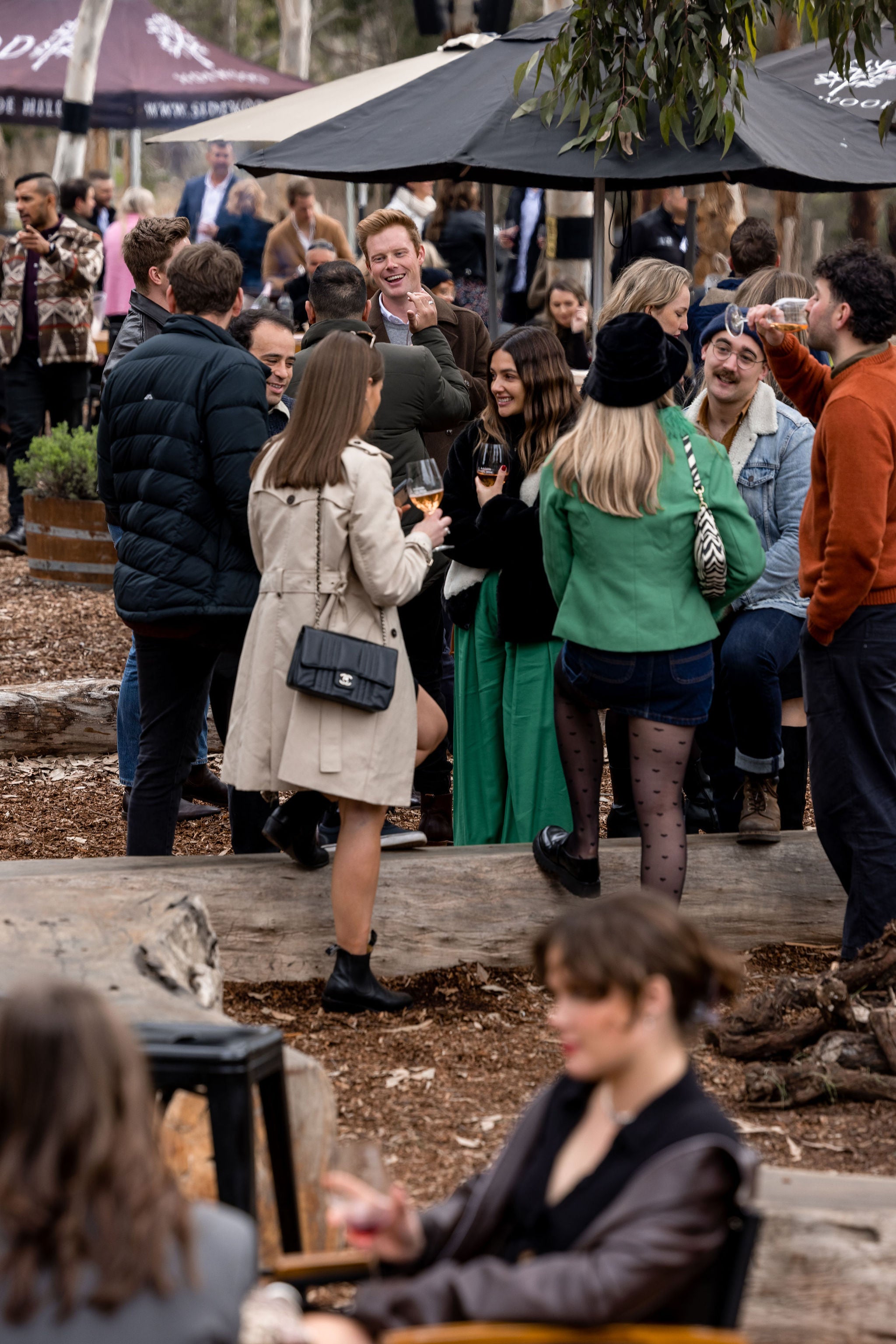 People socializing outdoors under umbrellas in a casual setting